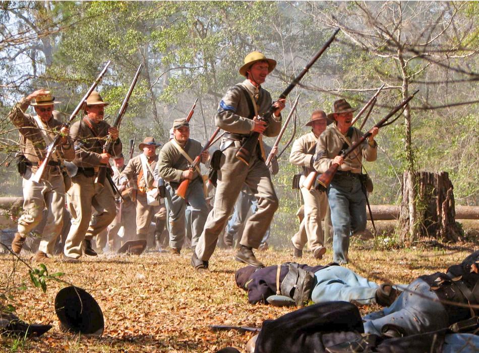 Confederate battle reenactors charge the field. 
